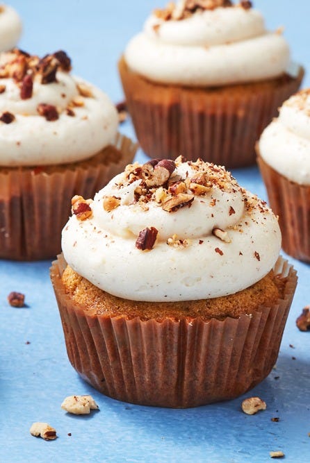 a close up of a carrot cake cupcake with white frosting on top