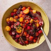 rainbow carrot and date tzimmes topped with parsley in a yellow bowl