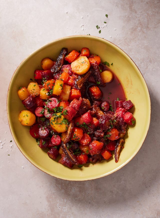rainbow carrot and date tzimmes with parsley in a yellow bowl