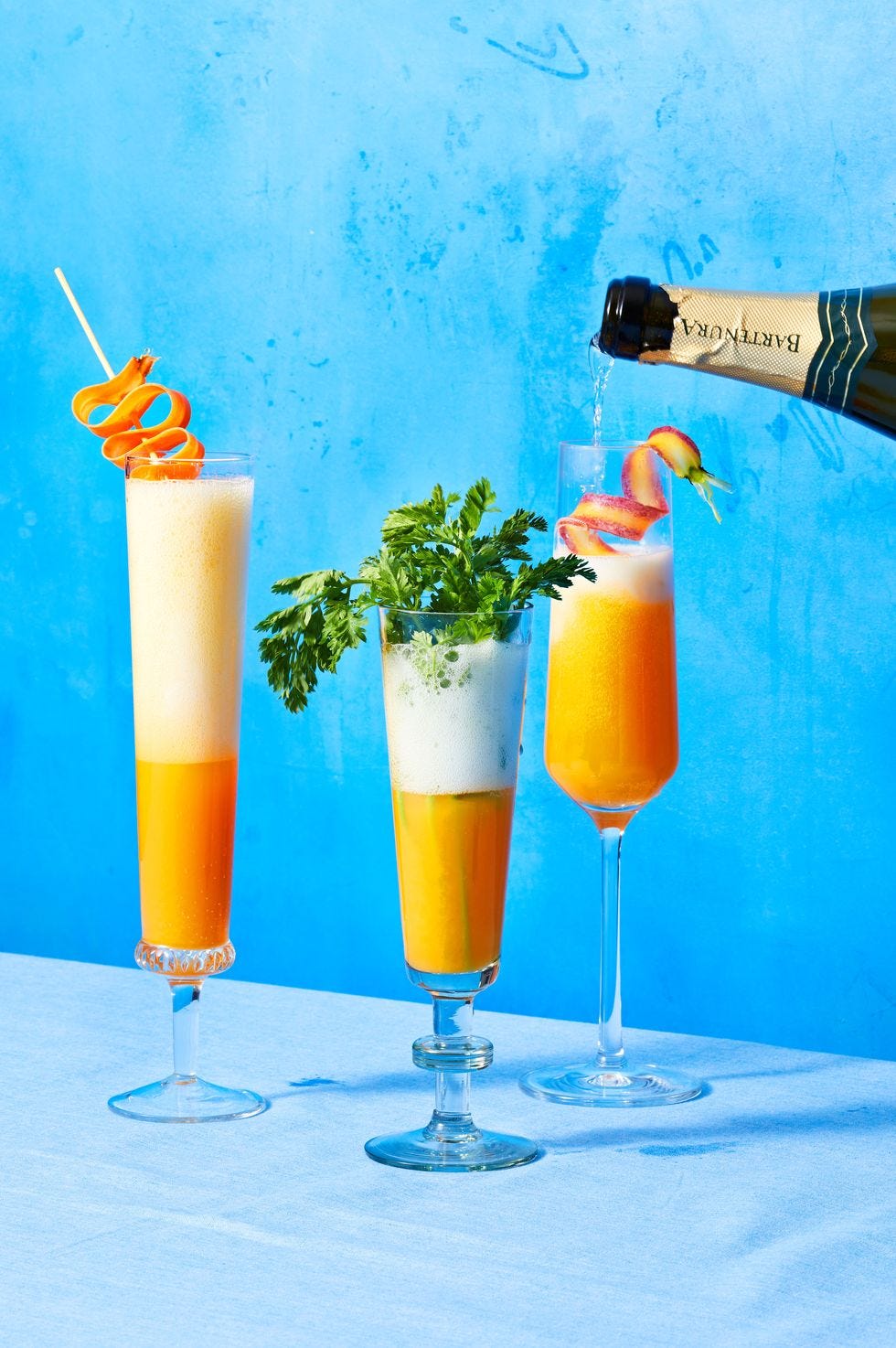 three carrot mimosas served in champagne flutes