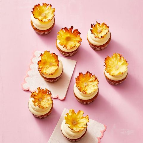 carrot pineapple cupcakes on a pink background