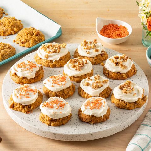 carrot cake cookies with frosting and orange sprinkles and nuts