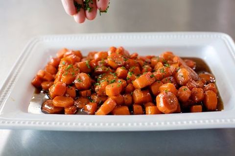 whiskey glazed carrots with hand sprinkling herbs