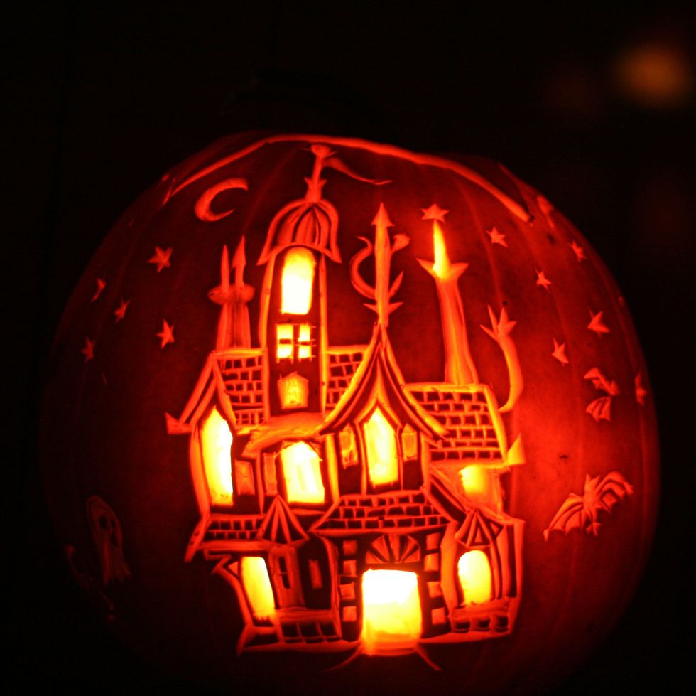 carved pumpkin with haunted house