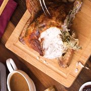 slicing turkey on wooden carving board