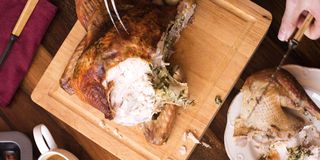 slicing turkey on wooden carving board