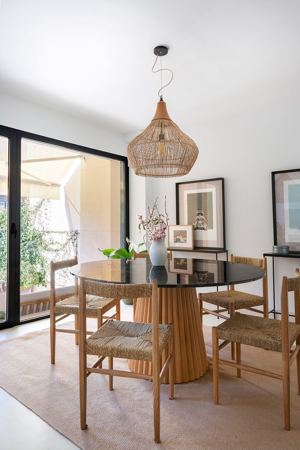mesa de comedor de madera con sobre redondo de mármol y sillas de fibras