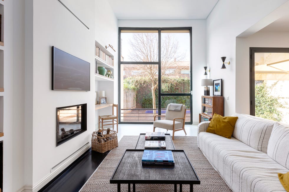 salón con chimenea moderna y sofá con tapizado a rayas
