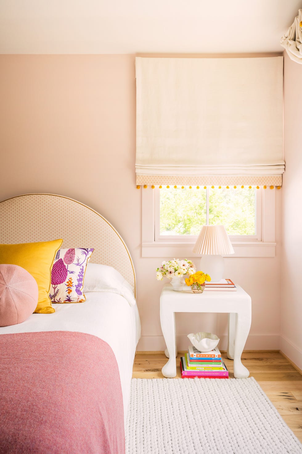 habitación infantil con cabecero circular y mesita blanca