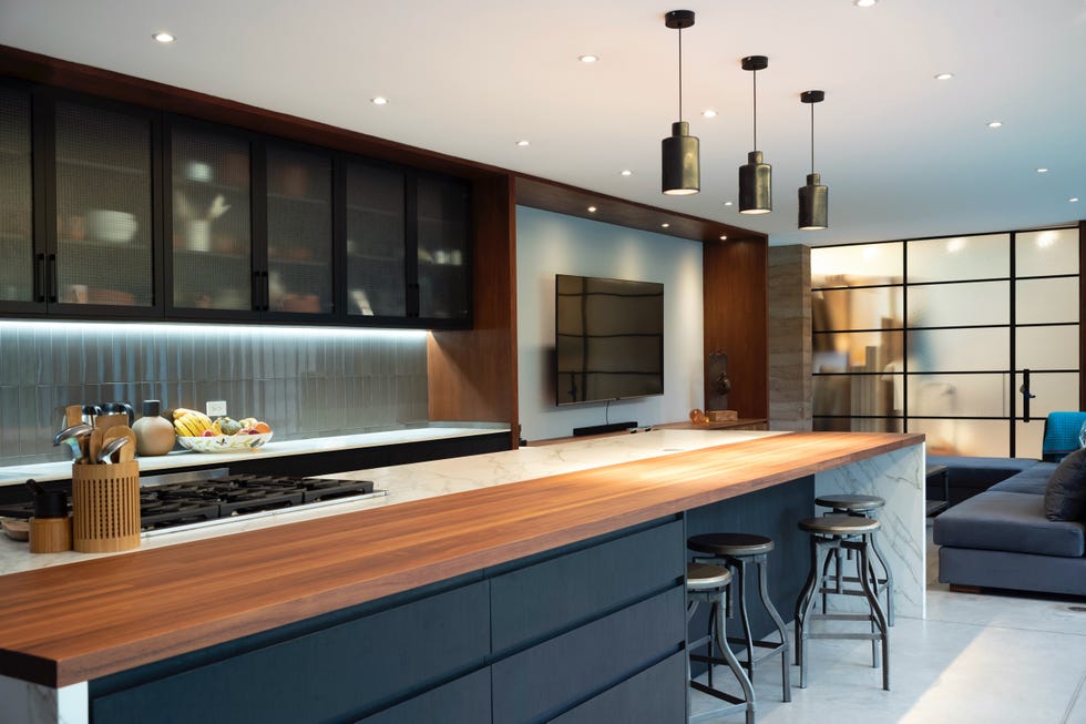 cocina abierta con isla de mármol y encimera de madera