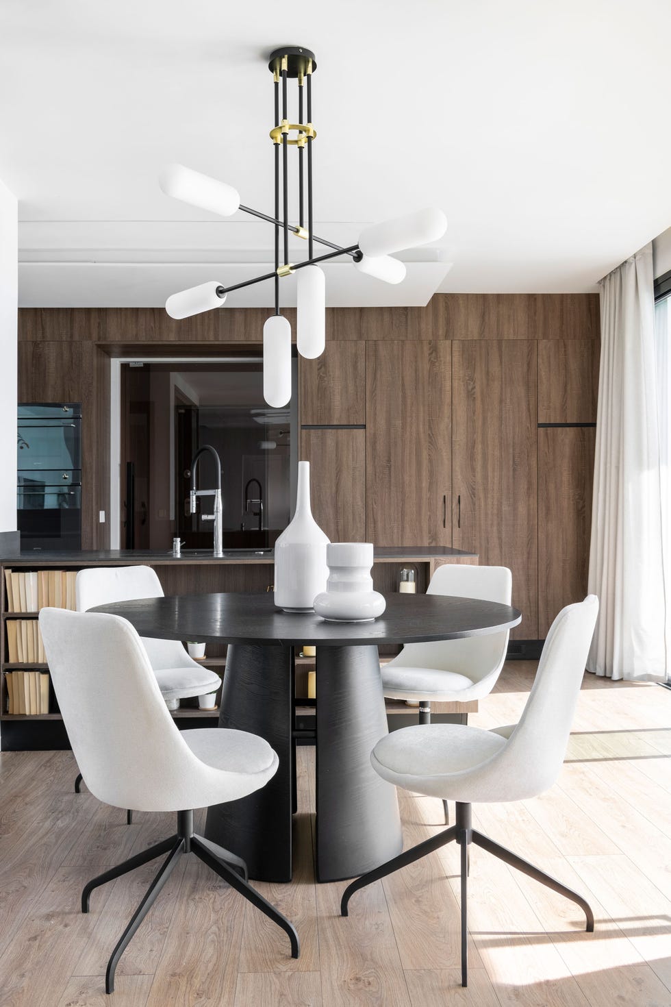 comedor de diseño contemporáneo y minimalista con mesa redonda y sillas tapizadas en gris