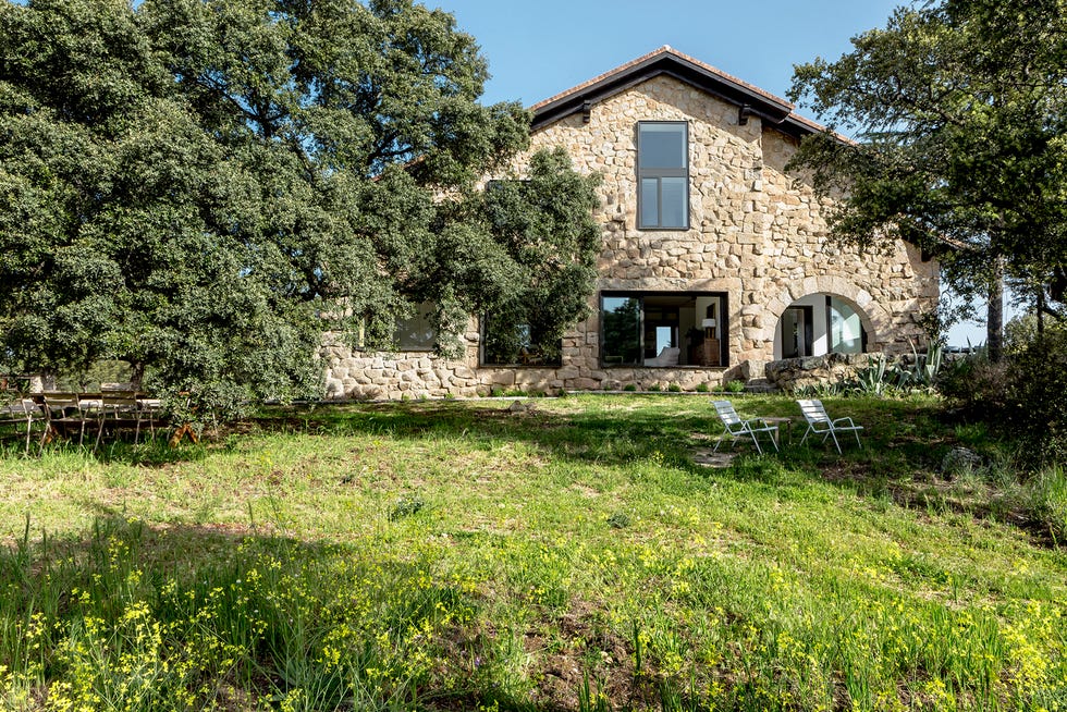 casa de campo ls, del estudio ábaton vivienda en piedra con muebles de diseño