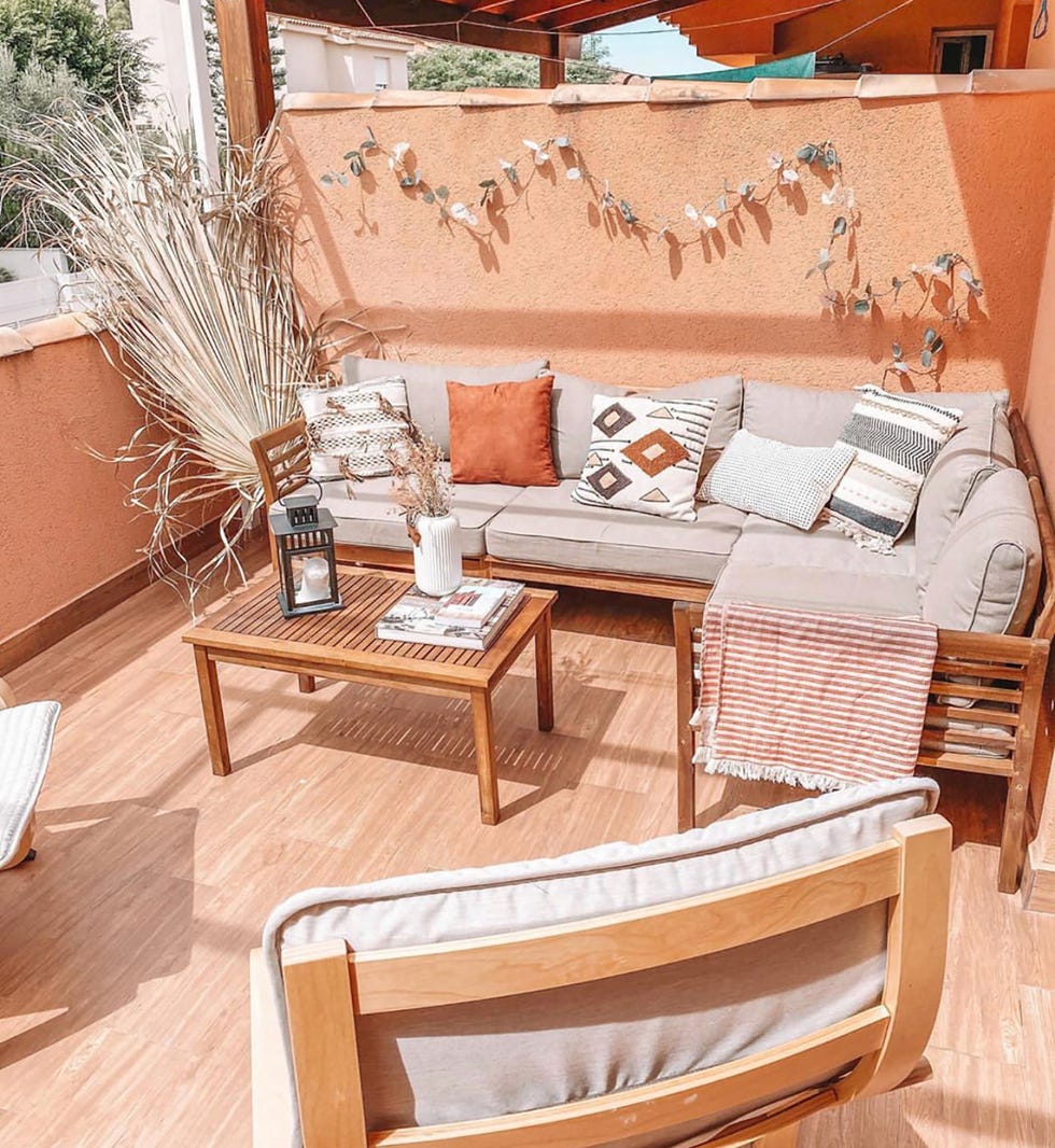 terraza de estilo boho con muebles de madera y textiles grises y terrosos