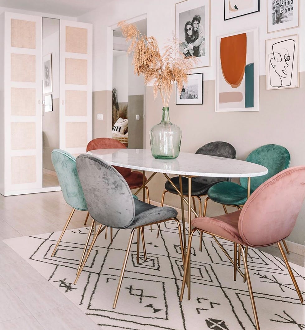 comedor boho chic con mesa de mármol y sillas de terciopelo en colores pastel