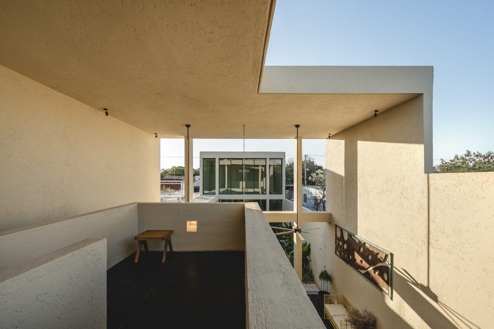 casa de hormigon, estrecha y alargada, que resuelve la distribucion en dos volumenes conectados por un patio