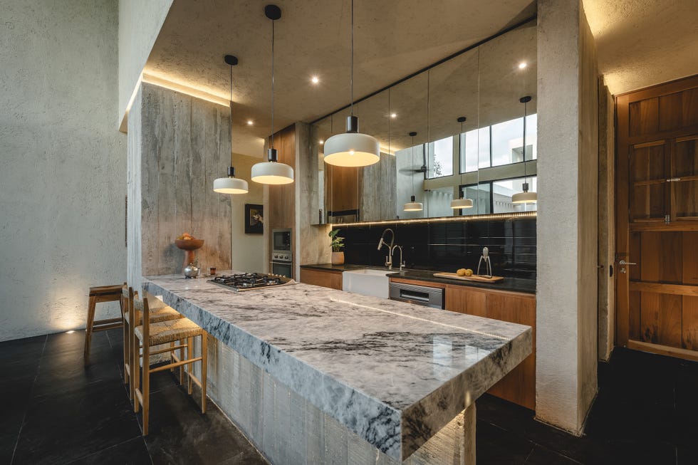 casa de hormigon, estrecha y alargada, que resuelve la distribucion en dos volumenes conectados por un patio