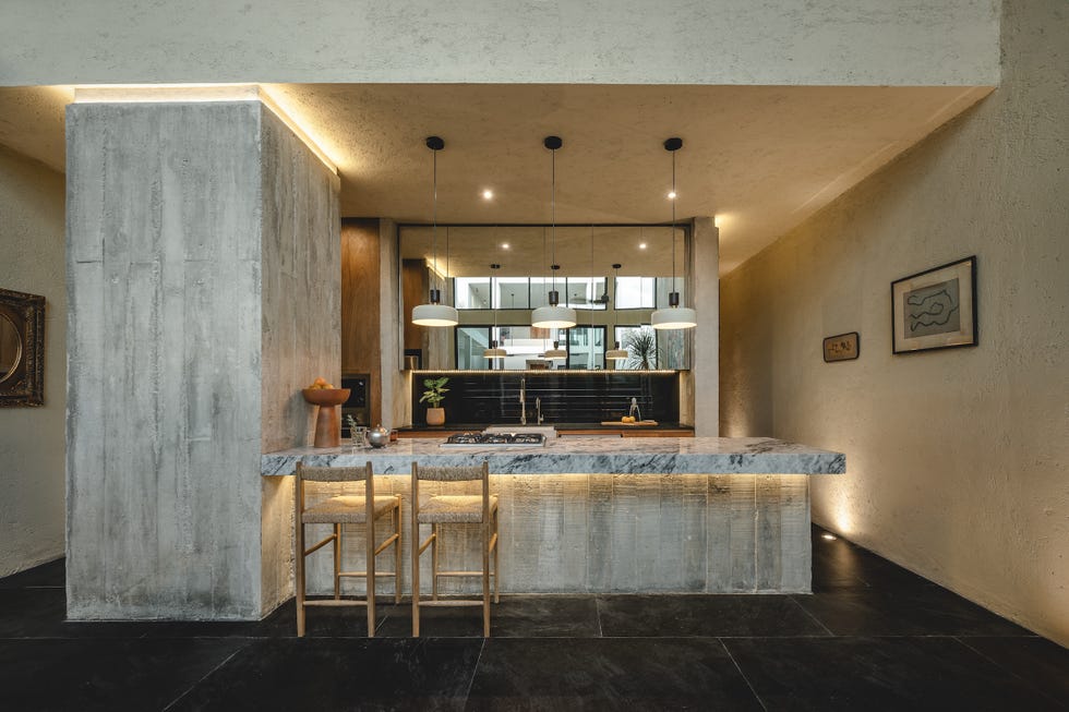 casa de hormigon, estrecha y alargada, que resuelve la distribucion en dos volumenes conectados por un patio