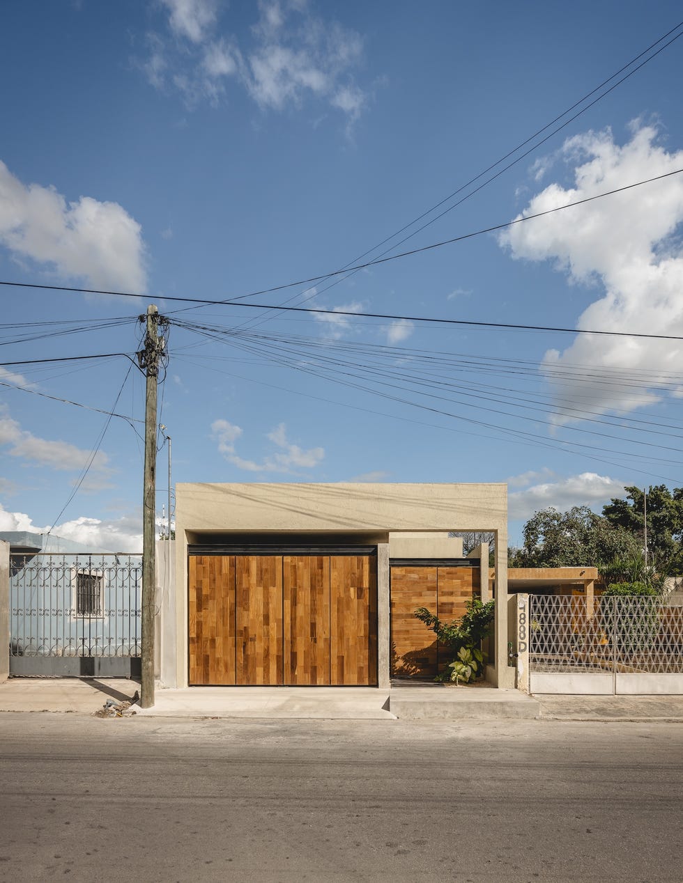 casa de hormigon, estrecha y alargada, que resuelve la distribucion en dos volumenes conectados por un patio