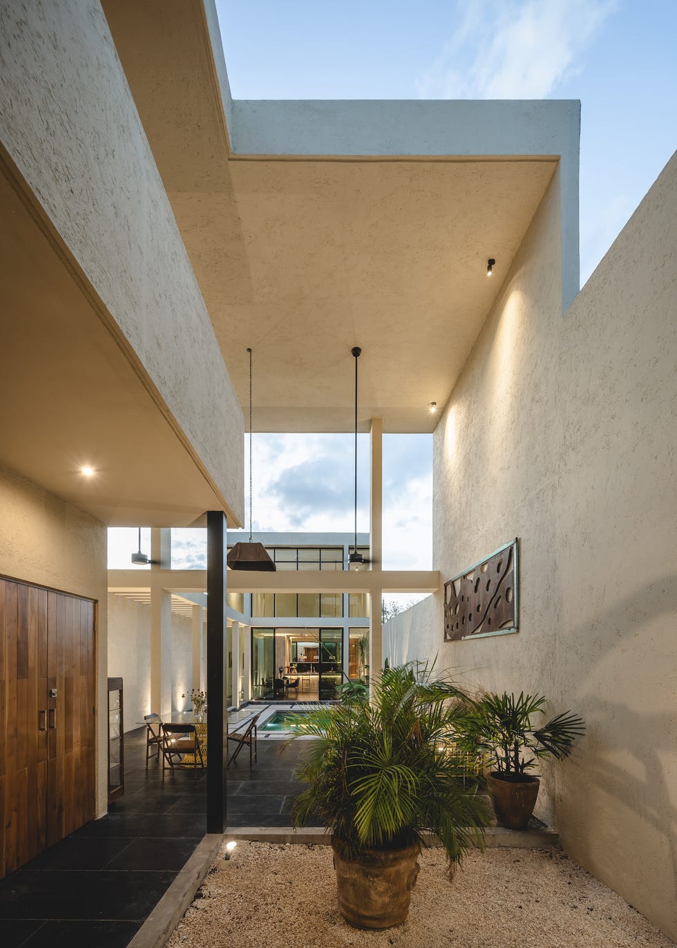 casa de hormigon, estrecha y alargada, que resuelve la distribucion en dos volumenes conectados por un patio