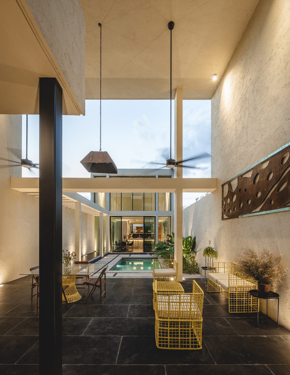 casa de hormigon, estrecha y alargada, que resuelve la distribucion en dos volumenes conectados por un patio