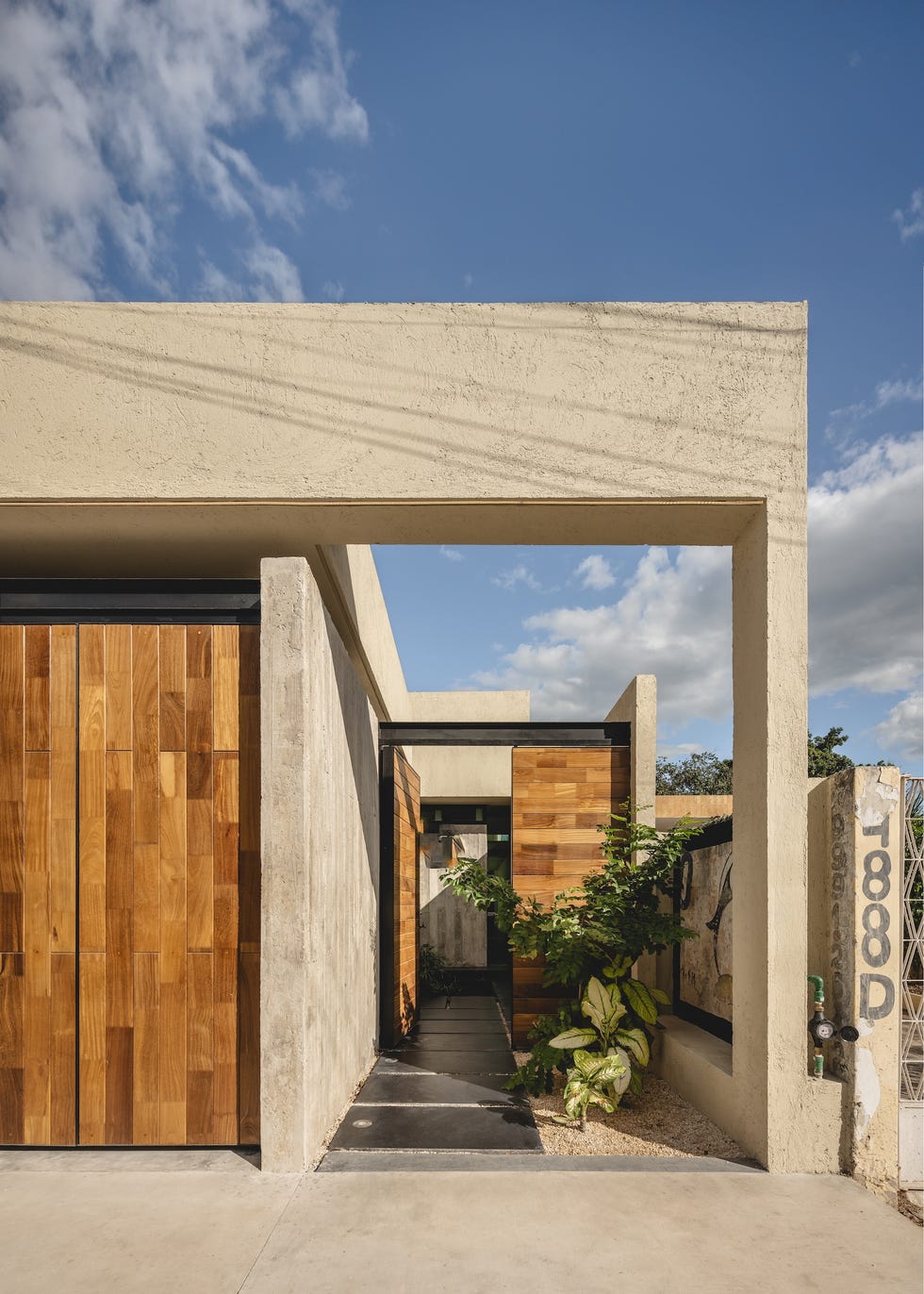 casa de hormigon, estrecha y alargada, que resuelve la distribucion en dos volumenes conectados por un patio