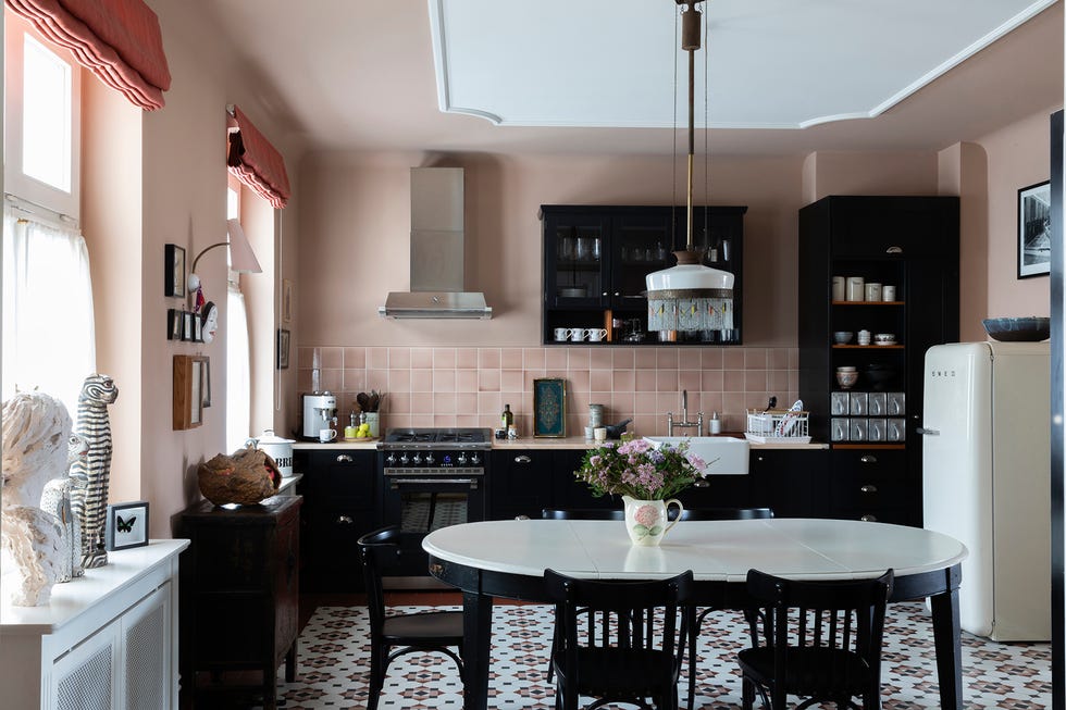 cocina con paredes rosas y muebles en negro con aires vintage