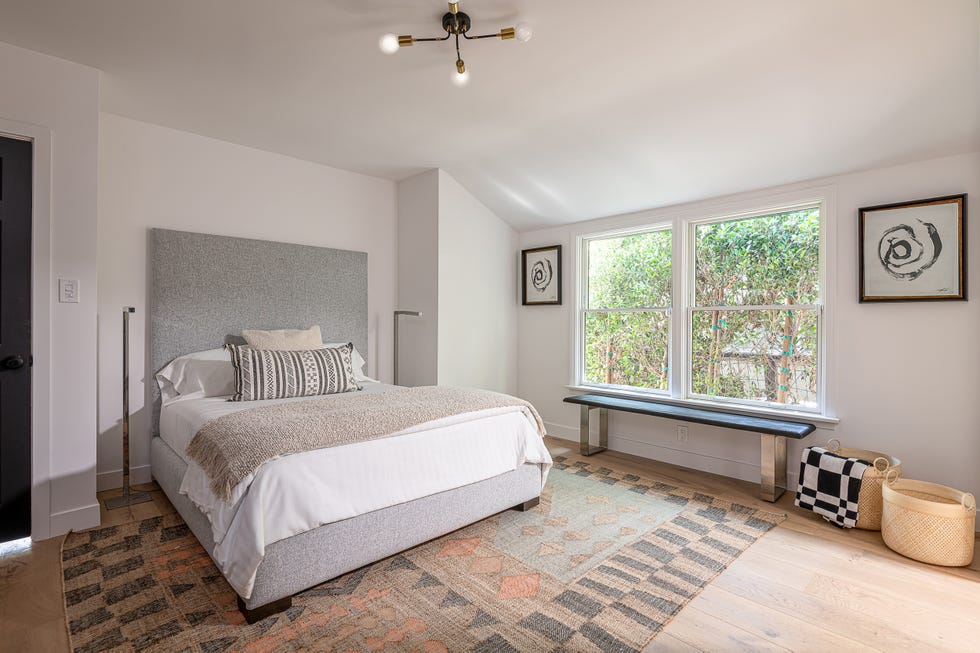 dormitorio moderno con alfombra kilim y cama tapizada en tela gris
