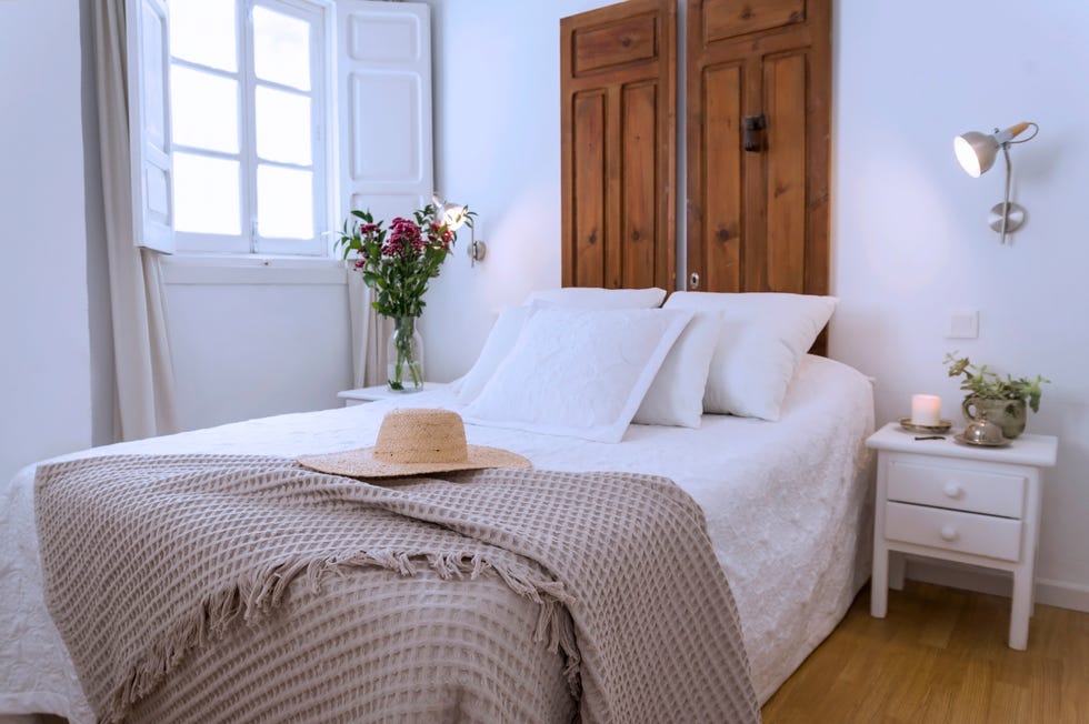 dormitorio rústico con cabecero hecho con puertas de madera recuperadas