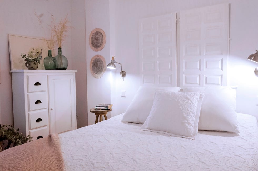 dormitorio rústico con cabecero hecho con puertas de madera recuperadas