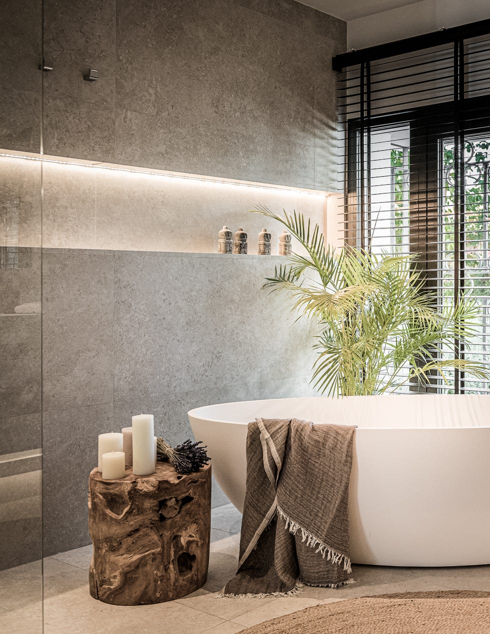 baño moderno con bañera exenta y mesa auxiliar de madera