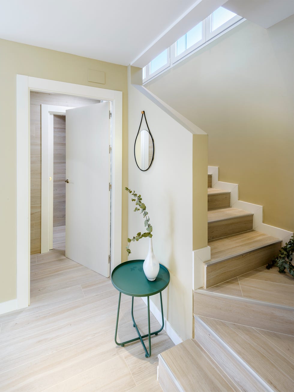 escalera con pequeño recibidor y peldaños de tarima efecto madera