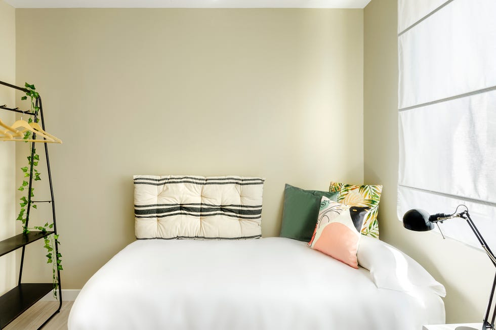 cama con cojines florales y estampados, y vestidor abierto de color negro