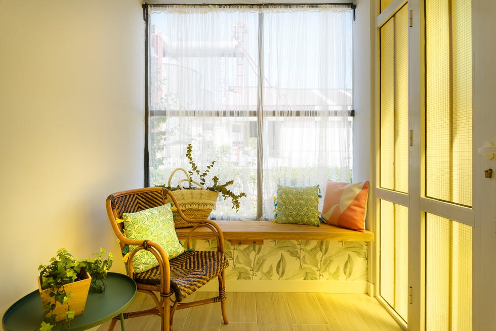 vestidor con butaca de fibras y banco de madera decorado con papel pintado botánico