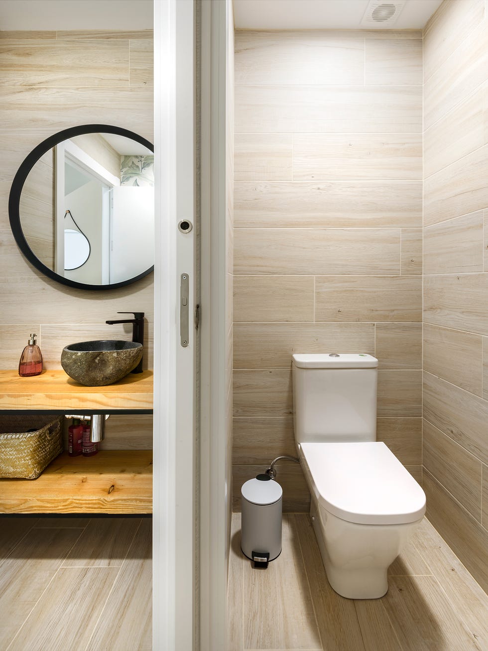 baño con puerta corredera que separa el lavamanos del sanitario