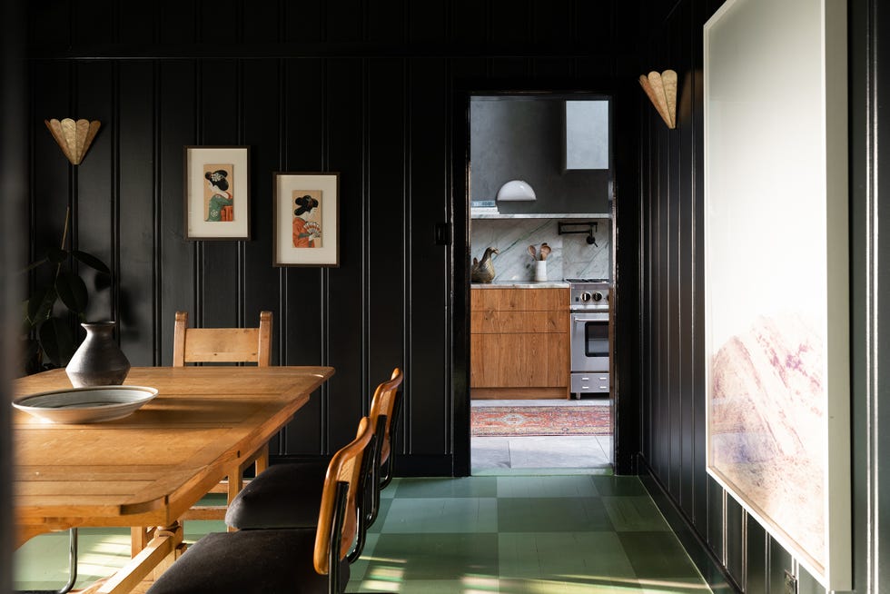 comedor vintage con mesa y sillas de madera y paredes de lamas de madera negras