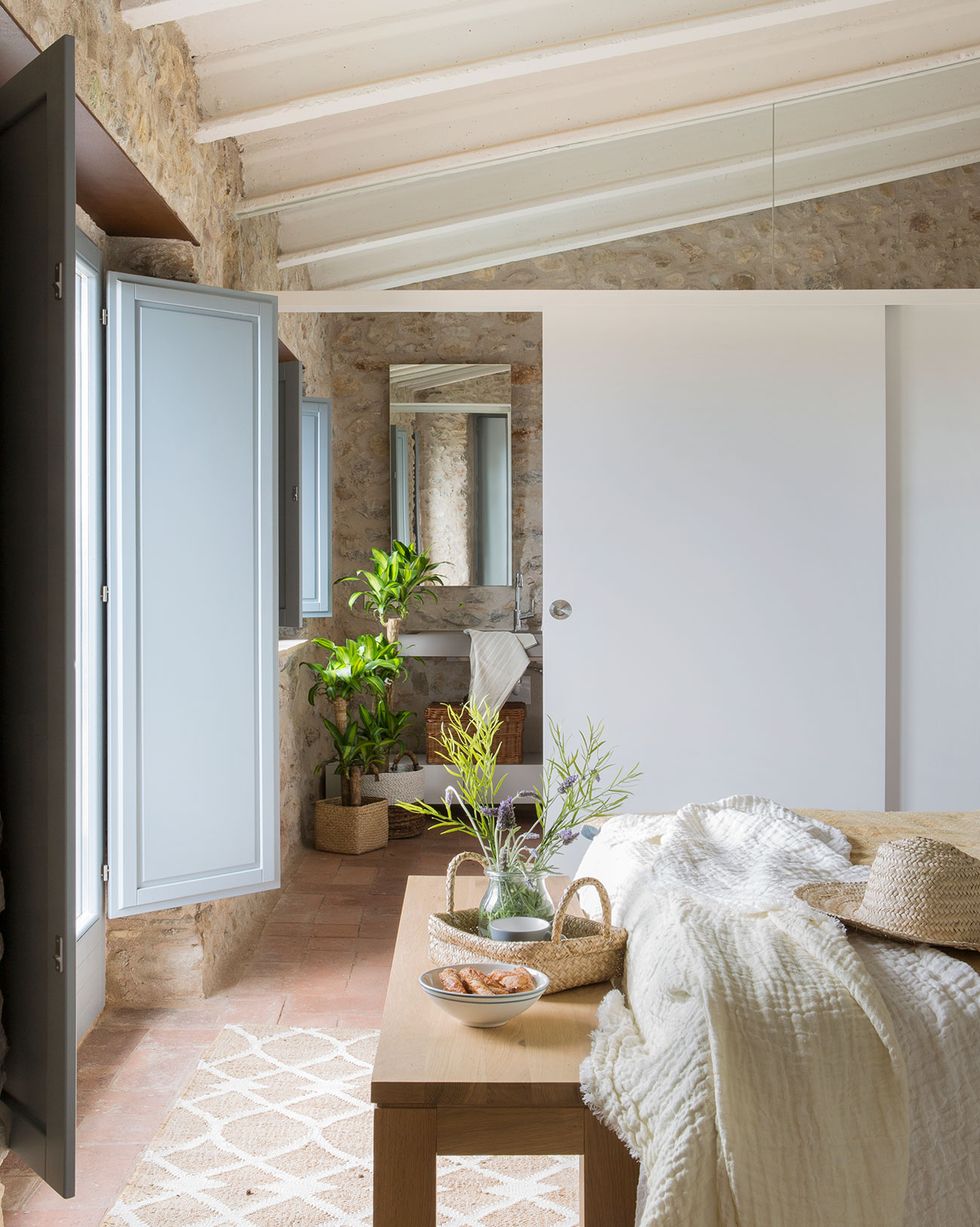casa de campo con puerta corredera blanca para separar el dormitorio y el baño, con techos abovedados al aire