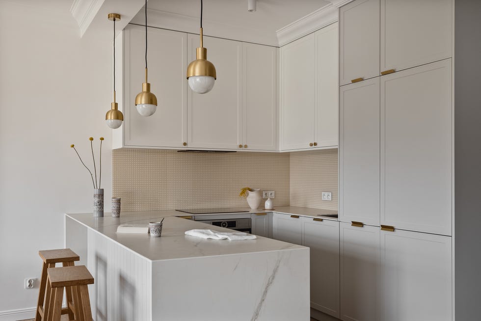 cocina en u con armarios grises y blancos y encimera efecto mármol