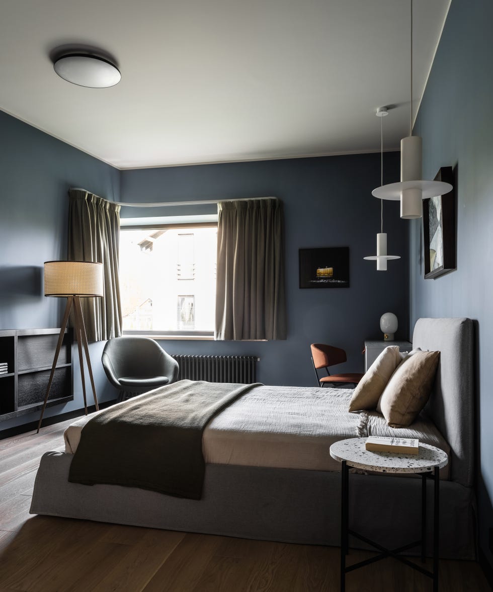 dormitorio con cama gris y paredes azules
