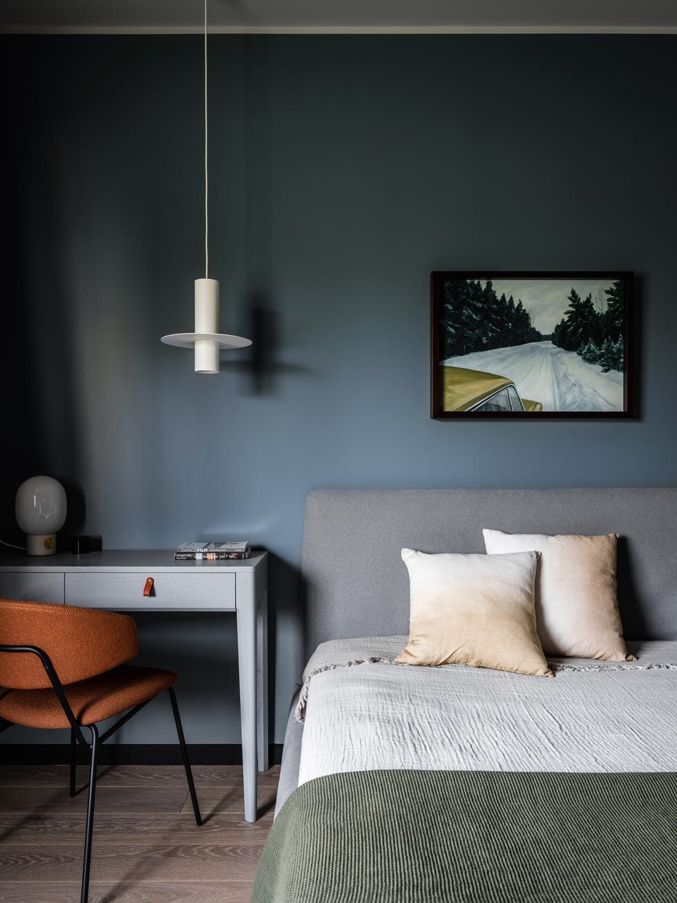 dormitorio con cama gris, paredes azules y escritorio azul con silla en color butano