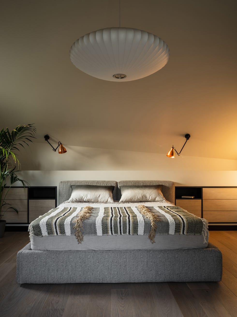 cama tapizada en tela gris y cabecero de obra