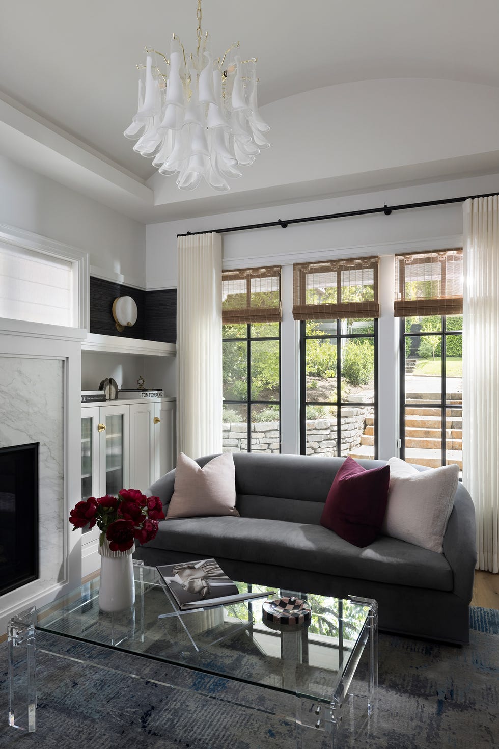 salón con sofá gris y mesa de centro de cristal