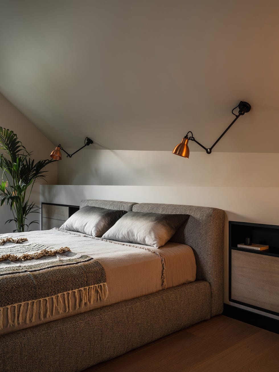 cama tapizada en tela gris y cabecero de obra