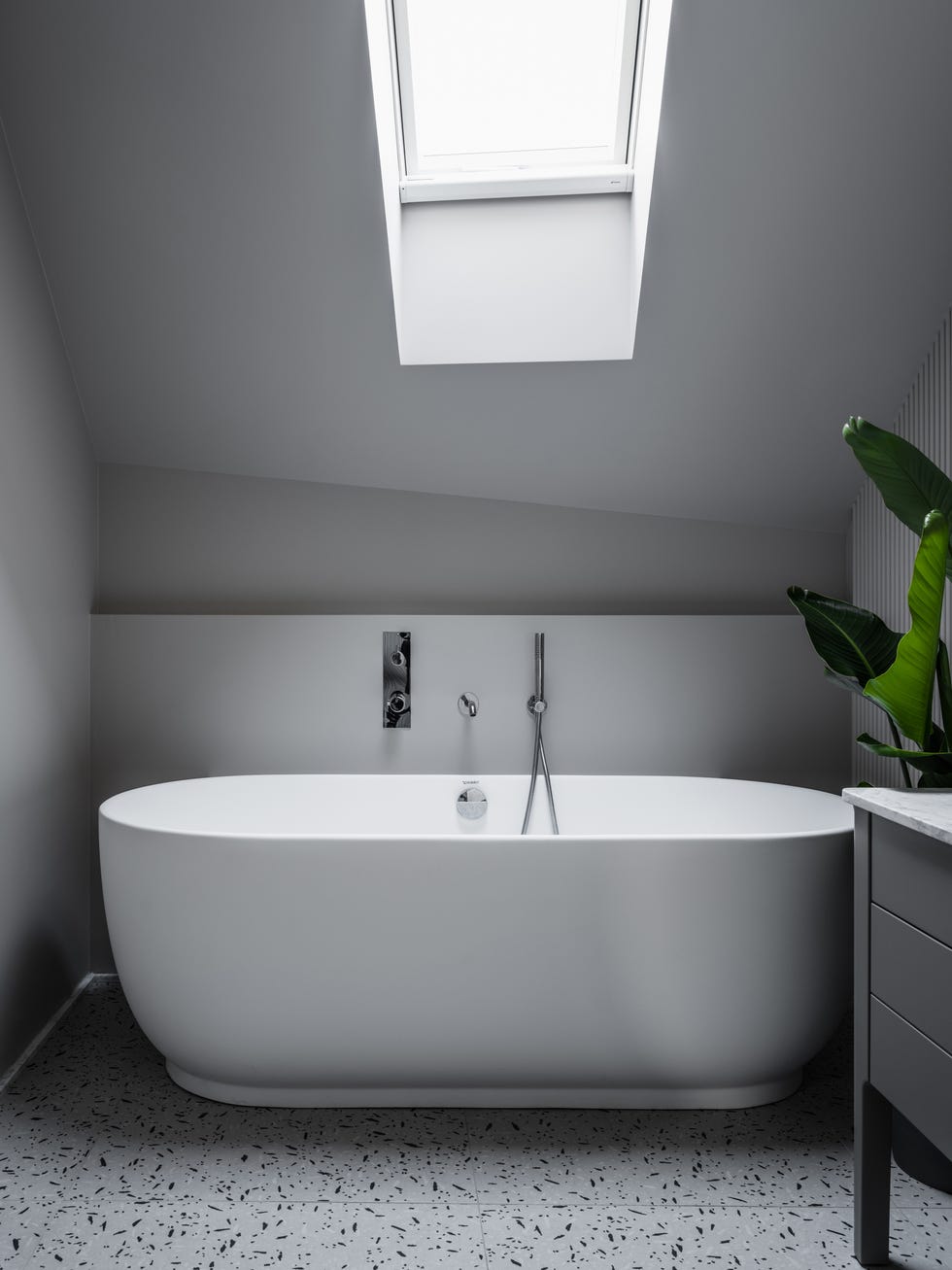baño gris con bañera exenta y suelo de terrazo