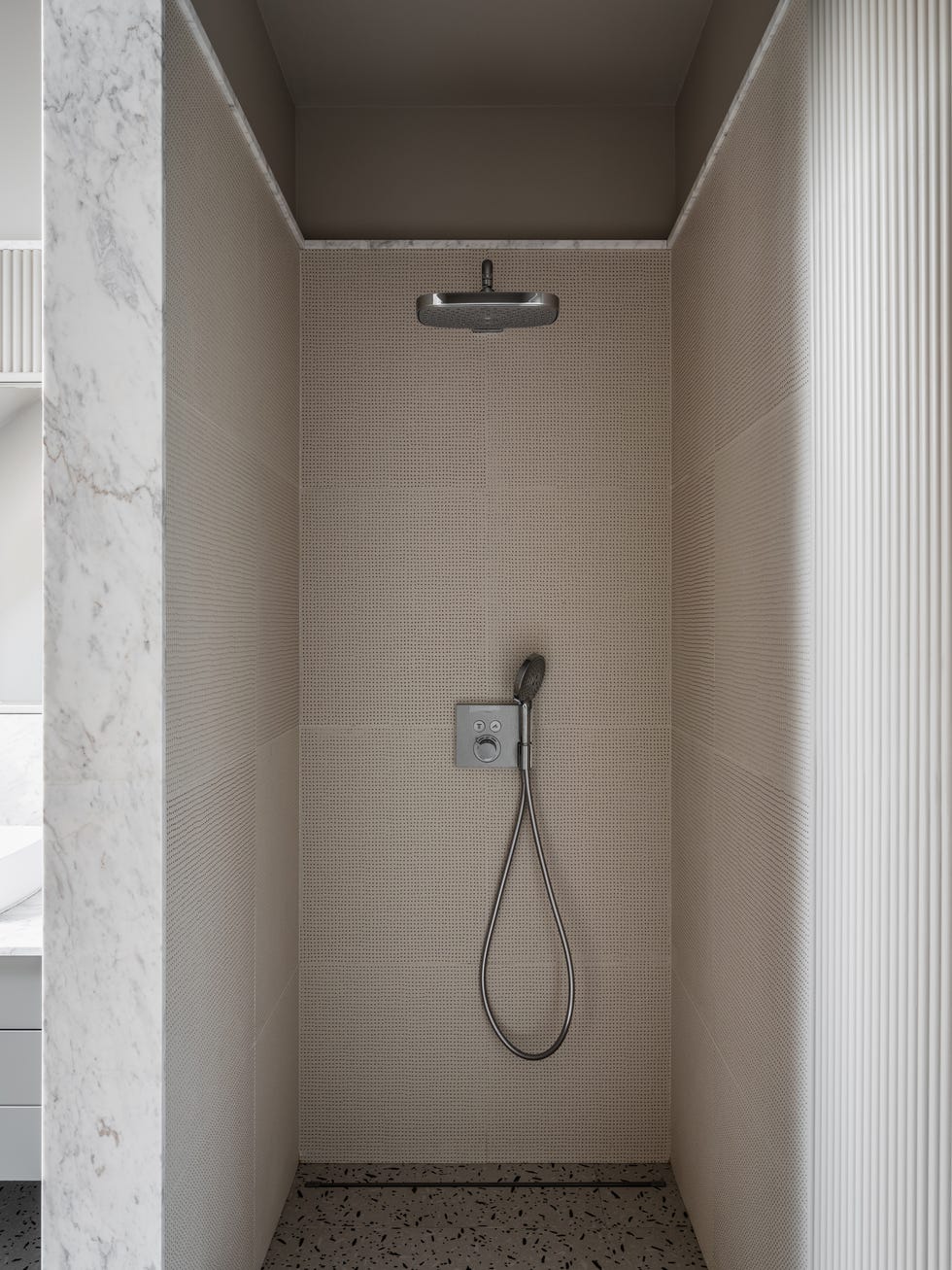 ducha abierta con suelo de terrazo y azulejos con textura