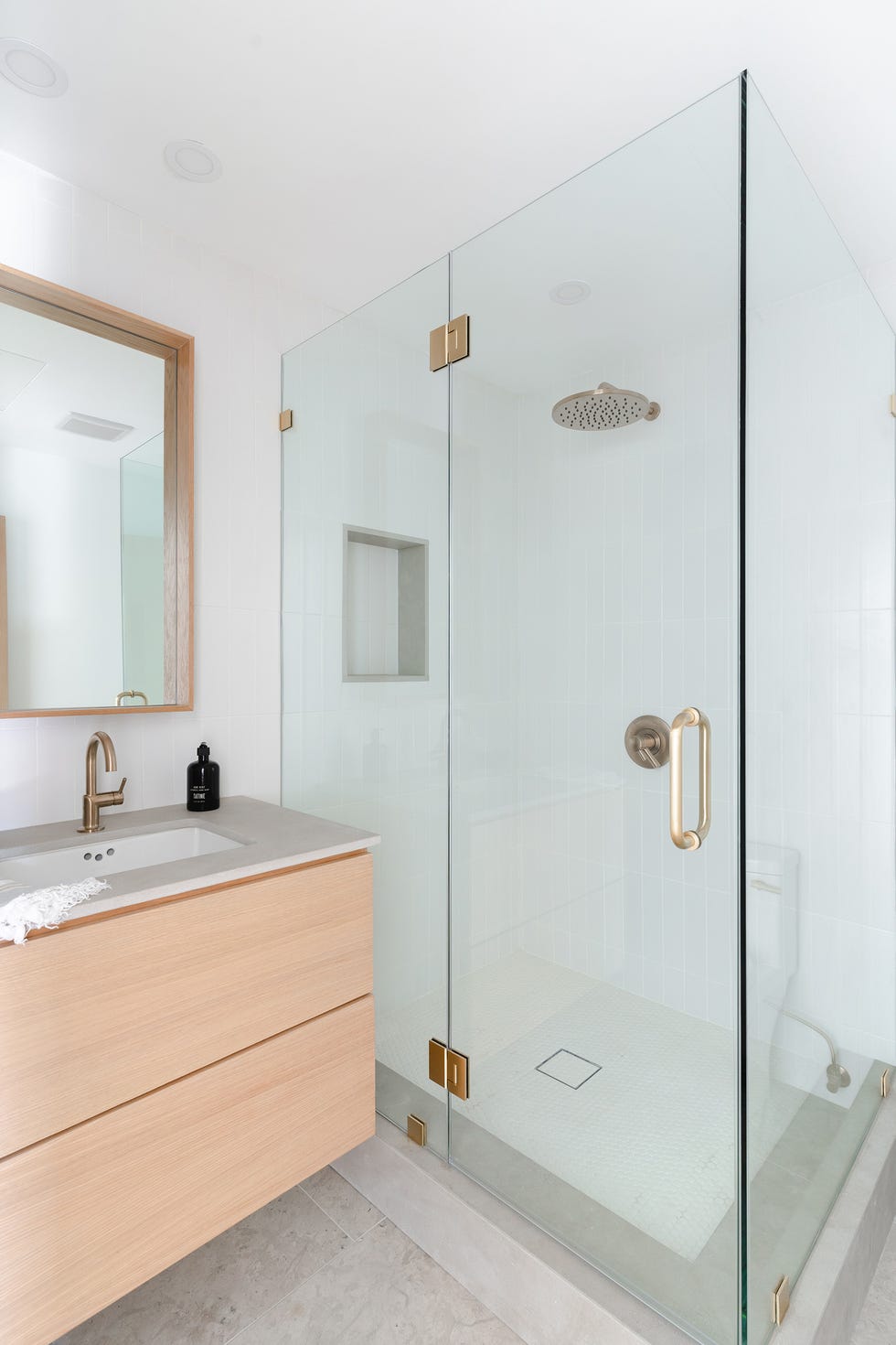 baño moderno con ducha de obra, mampara de vidrio y mueble bajo lavabo suspendido de madera