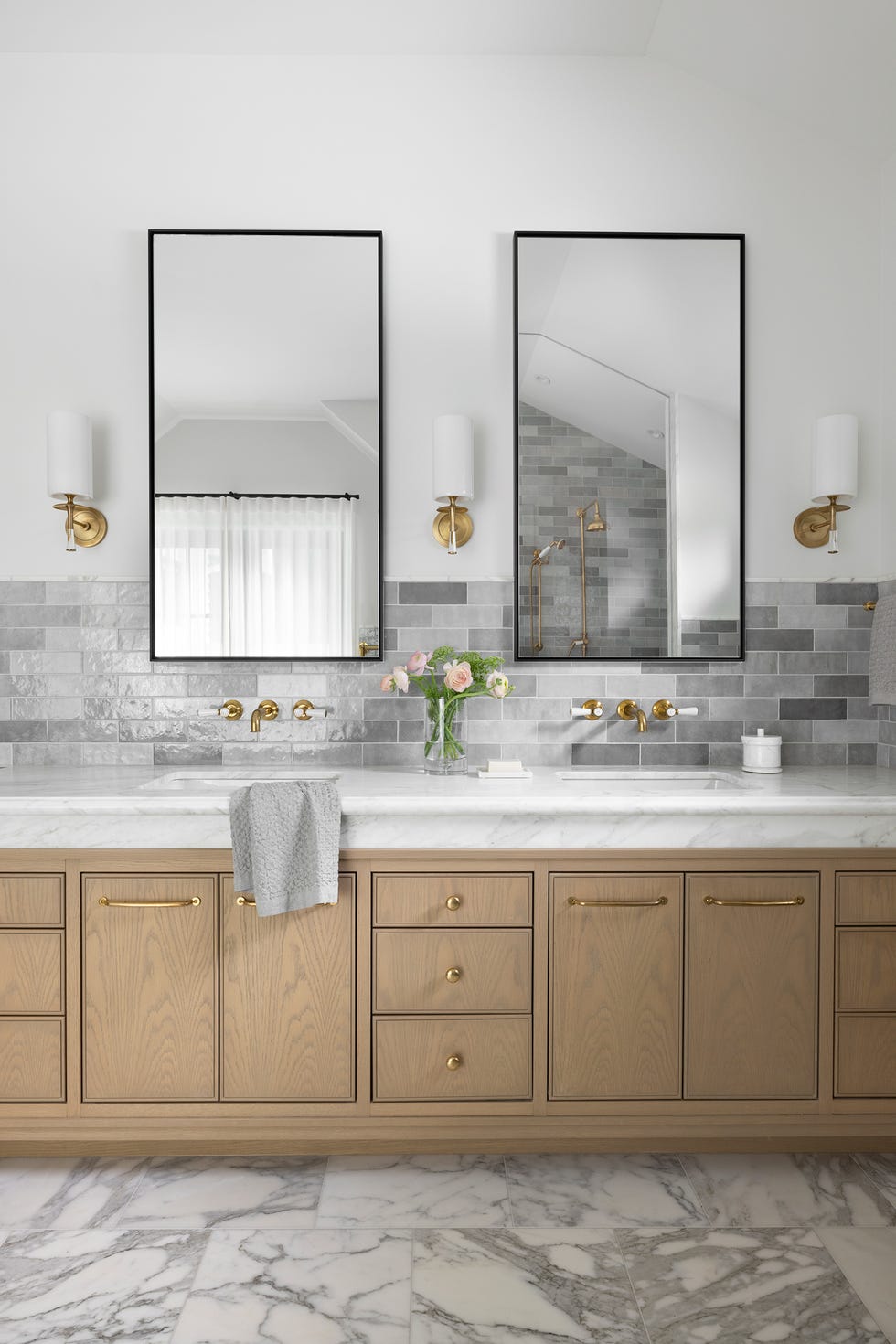 baño con mueble de madera y revestimientos de mármol