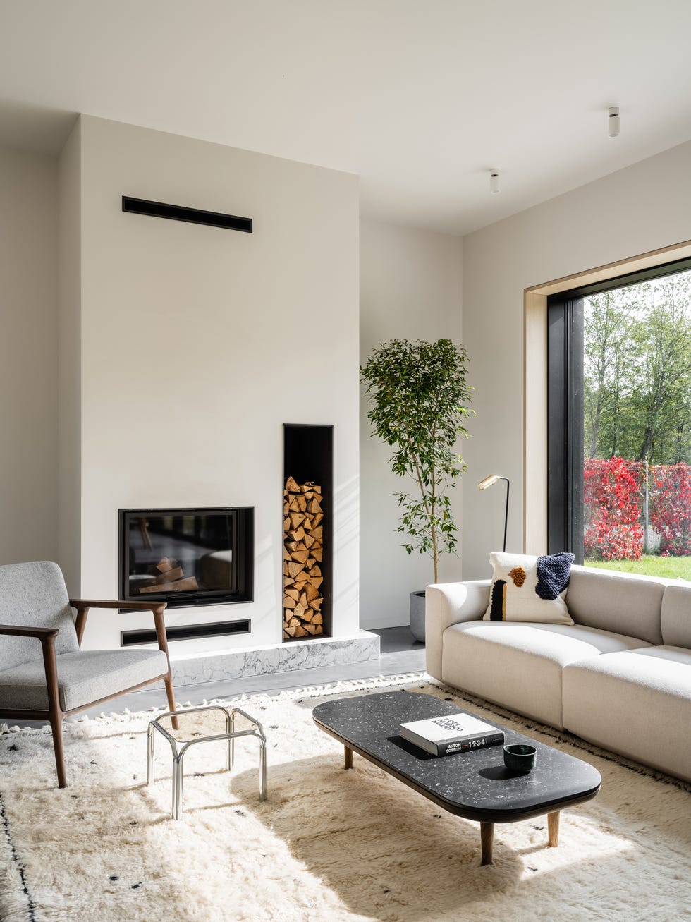 salón de diseño contemporáneo decorado en tonos blancos y grises con chimenea