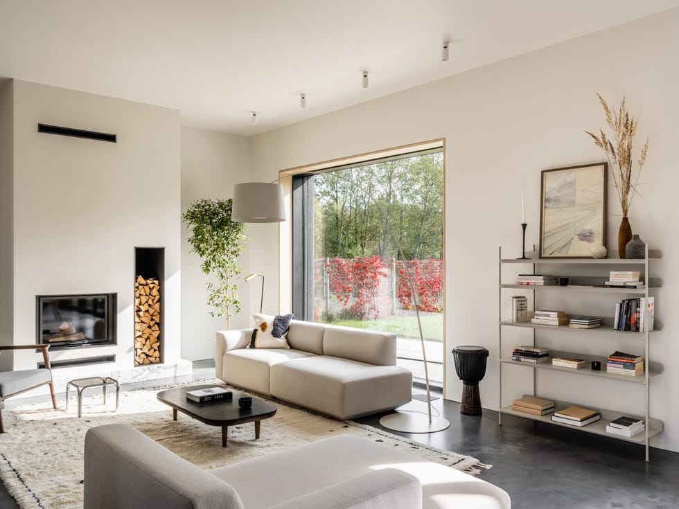salón de diseño contemporáneo decorado en tonos blancos y grises con chimenea