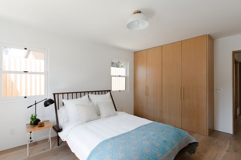 dormitorio minimalista con cama de forja y armario de madera