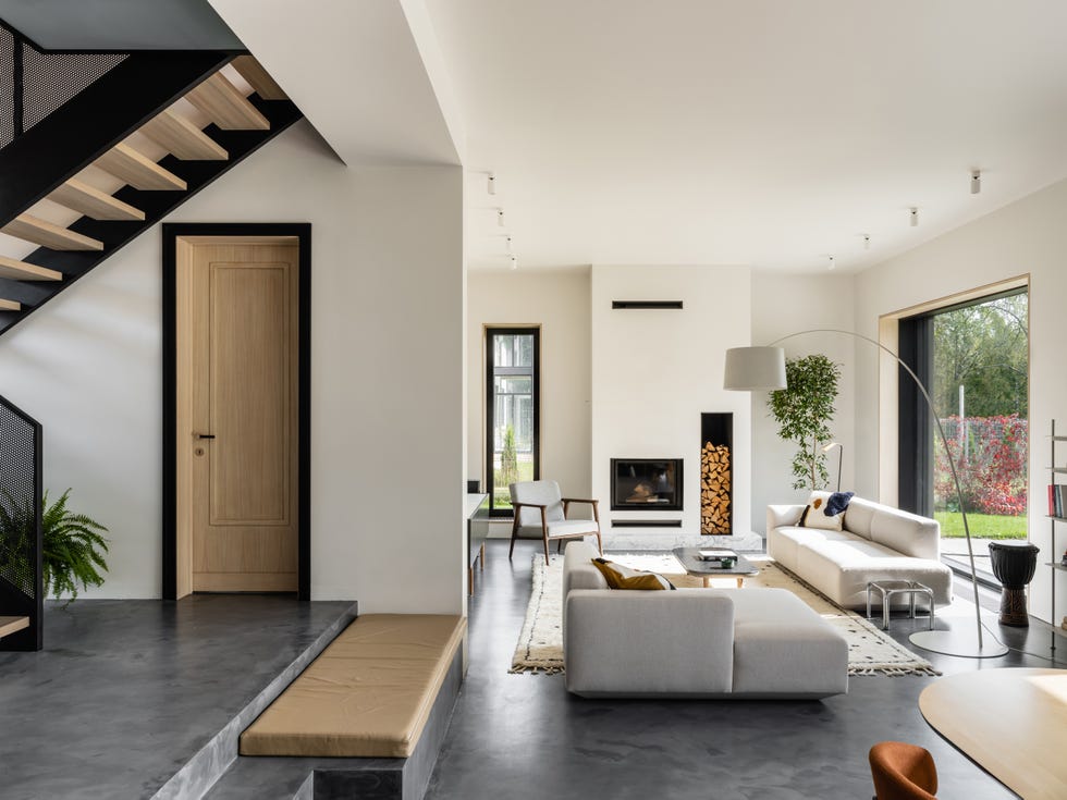 salón de diseño contemporáneo decorado en tonos blancos y grises con chimenea